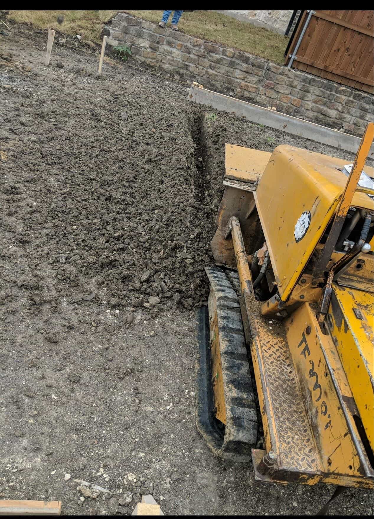 Yellow construction equipment with shovel attachment on dirt ground at a job site